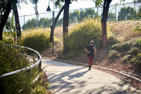Young man jogging in park in summer