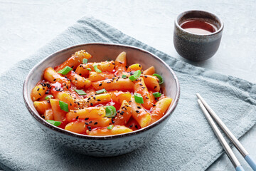 Tteokbokki or topokki, Korean street food, spicy rice cakes in red pepper gochujang sauce, a popular dish in a cafe