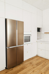 Modern minimal kitchen design. Stylish white kitchen cabinets with brass knobs, granite counter and appliances in new scandinavian house. Modern kitchen interior.