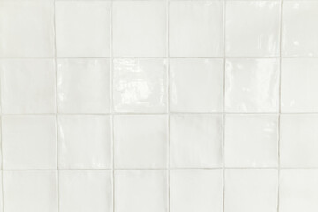 Modern white square tiles background. Installed modern rustic tiles wall close up in kitchen in new...