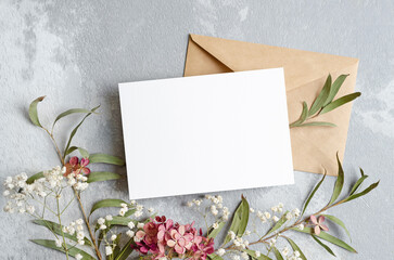 Wedding invitation card mockup with envelope and flowers, blank card mockup on grey