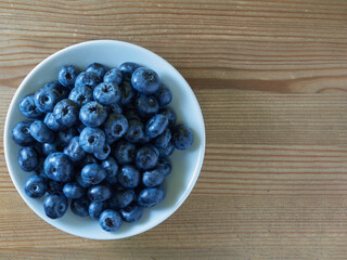 Freshly picked blueberries in a white vintage ceramic bowl. Selective focus, Free text space.