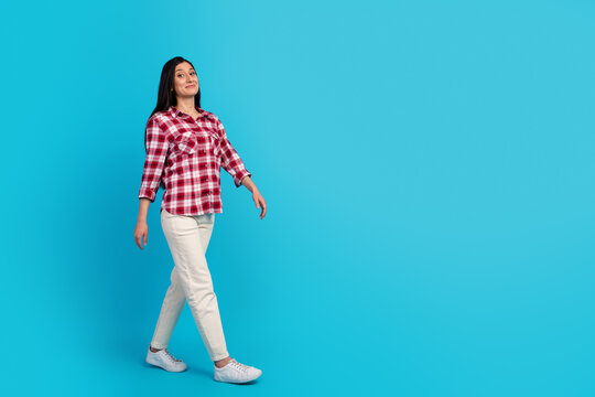 Full body photo of young woman walk to shopping center good mood isolated over blue color background