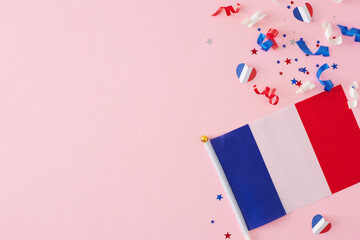 Celebration concept for France's Bastille Day holiday. Top view composition of french flag, stars, sparkles, hearts on pastel pink background with blank space for ads or text