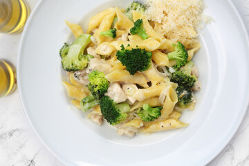  Pasta in a white sauce with broccoli and cheese. Penne, Italian dish with chicken, mediterranean cuisine, top view.