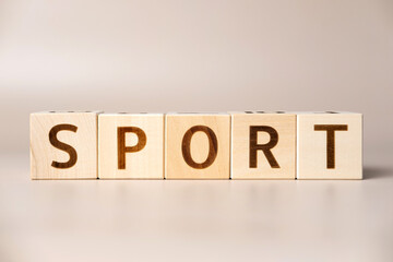 The word SPORT on wooden cubes on a beige neutral studio background. Copy Space. Written. Text words matter. Teamwork, Ideas for corporation concept. Fitness, health care. Activities, energy, life