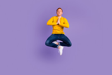 Full-body portrait of levitate man in the air meditating and concentrating isolated on shine...