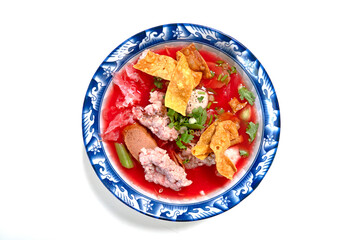 Yen Ta Fo  in pink soup with fish balls, crispy wontons, and jellyfish In an ancient patterned bowl on a white background