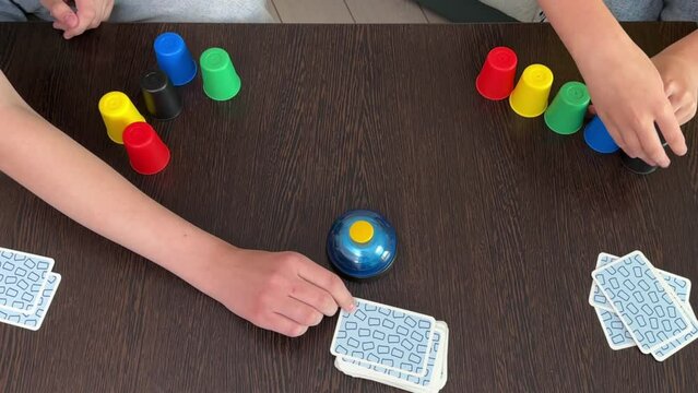 two girls are playing a board game with colorful figures and cards. The concept of children's leisure. children play board games at home on vacation.