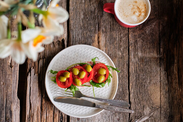 toast with arugula, olives and tomatoes. homemade bread. Top view. Wooden background.