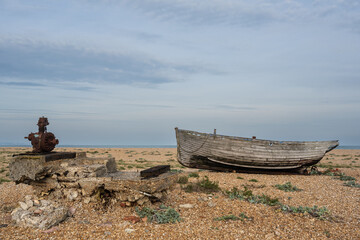 Abandoned fishing boat and detritus on a shingle beach