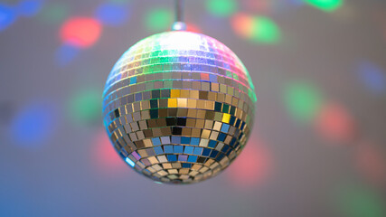 Dusty disco ball with colorful lights on wall. Disco dance oldies music and 80s party concept.