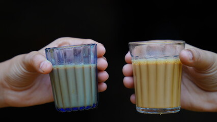 Fresh milk tea or Indian Kadak Chai. Milk tea , pouring tea Chai traditional beverage. Two glass of...