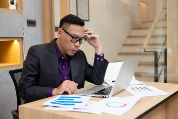 Serious and mad working. Overtime overwork at home office. Asian businessman typing on laptop during work at home office. Freelance working from home