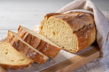 Bakery - Freshly sliced bread. Freshly baked bread on rustic wooden background.