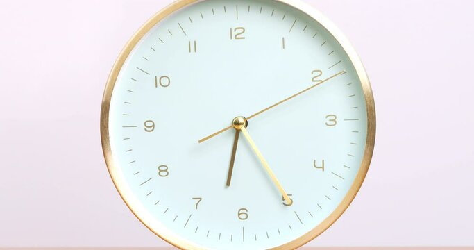 Time is Precious: Close-up of Gold Rimmed Table Clock Showing 6 o'clock on White Background.