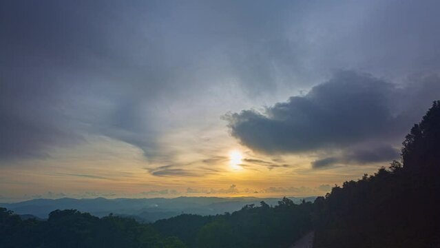 .Time lapse Beautiful sunset on the hill amid the mountain range with the setting sun in Phang Nga..Sunbursts flashed in the mountains range in beautiful sunset..Majestic sunset or sunrise landscape.