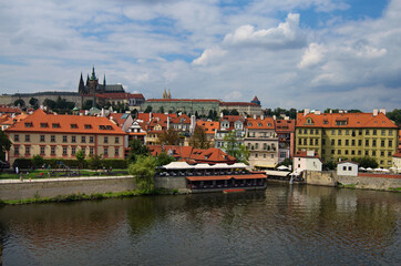 Obraz premium Beautiful cityscape view of the historical part of Prague. Famous Prague Castle with Saint Vitus Cathedral and typical historical buildings. Vltava River in the foreground. Prague, Czech Republic