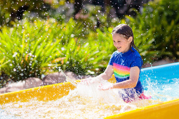 Kids on water slide in aqua park. Summer vacation