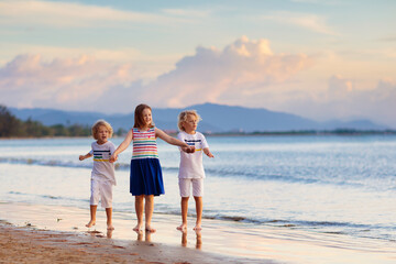 Kids play on tropical beach. Sand and water toy.