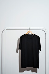 Black t-shirt displayed on clothes rack