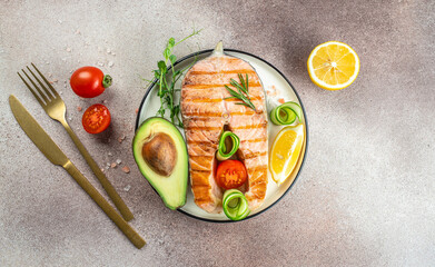 Grilled salmon steak with avocado and fresh vegetable salad. Keto diet, Healthy food concept. place for text, top view