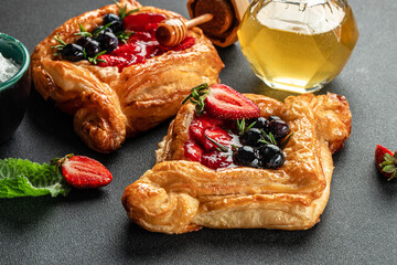 puff pastry, strawberry and honey on a dark background, Food recipe background. Close up