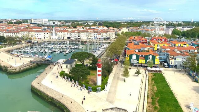 Red lighthouse and colored wooden houses of Le Gabut district in the old Port of La Rochelle, France