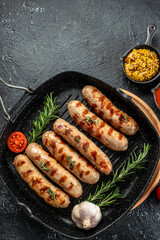 Barbecue sausages with rosemary in pan. meat sausages in skins with spices, vertical image. place...