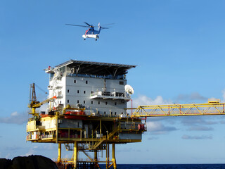 The Helicopter from onshore landing on offshore buildings for passenger transfer to work at offshore oil and gas platforms (take a photo from a boat of offshore marine service) © Tinglee