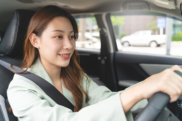 confident woman takes charge as she sits behind the wheel of a car. Her poised and determined expression exudes a sense of empowerment and control