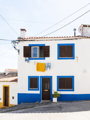 Traditional white and blue stone house with tiled roof