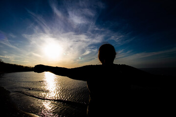 silhouette of a person standing on a rock