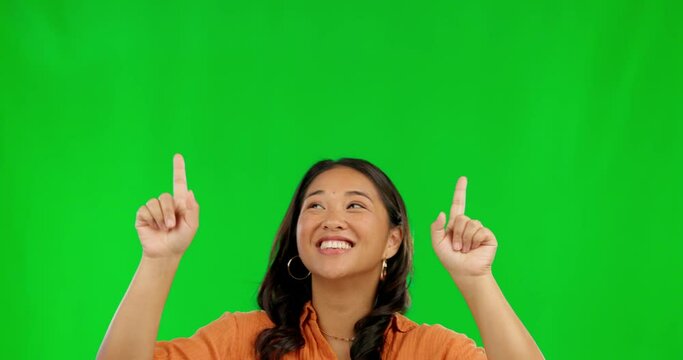 Happy asian woman, pointing and advertising on green screen against a studio background. Female person finger point for advertisement, sale discount or deal in notification, alert or news on mockup