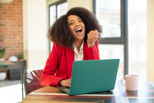 pretty afro black woman feeling shocked,laughing and celebrating success. businesswoman and laptop concept