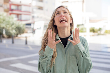 Fototapeta premium pretty woman looking desperate and frustrated, stressed, unhappy and annoyed, shouting and screaming