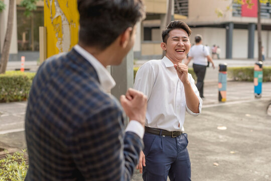 Two workmates make playful boxing stances while bonding each other, clowning around. A good and solid friendship.