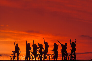Group of teenagers on bicycles at sunset