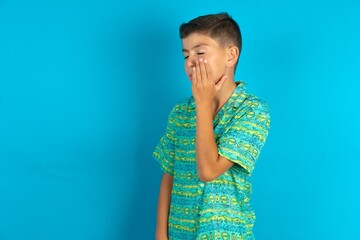 Little hispanic boy wearing green aztec shirt with toothache