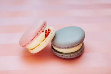 Two different colors macaroons on pink background, card with dessert and sweet food