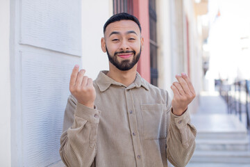 Naklejka premium young handsome man feeling happy, positive and successful, money concept and celebrating good results