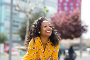 Cheerful young african american woman smiling outside in the city