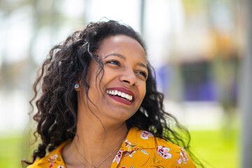 Pretty young mixed race woman looking away and smiling outside