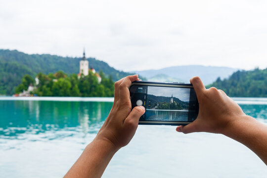 Child Taking a Photograph with phone of Lake Bled Island, Slovenia