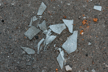 Shards of broken glass on the ground. Broken glass on asphalt