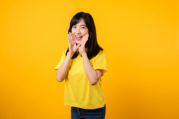 Portrait of a Young Asian Woman with Shout Hands Gesture Isolated on Yellow Studio Background