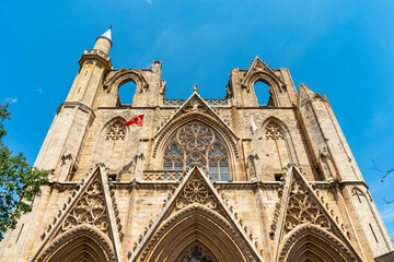 Fototapeta premium Lala Mustafa Pasha Camii Mosque or old Cathedral of Saint Nicholas with minaret in Famagusta or Gazimagusa historical city centre, Northern Cyprus. Selective focus.