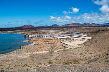 The Janubio salt flats, in Lanzarote, are the largest in the Canary Islands. They produce salt. They are located in a lagoon created by volcanic eruptions that created a lava barrier facing the sea.