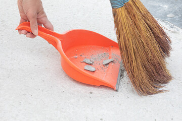 A broom sweeps debris on the floor.