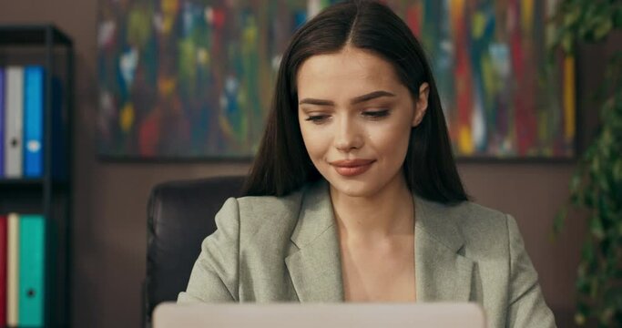 Close up shot selective focus on beautiful adorable woman in buisness who looks at papers and then in window buisness lady in good mood feeling relief after good interview presentation.